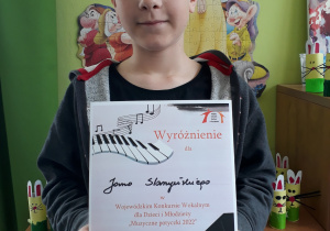 Jan Satrzyński z dyplomem za wyróżnienie w wojewódzkim konkursie wokalnym "Muzyczne potyczki"